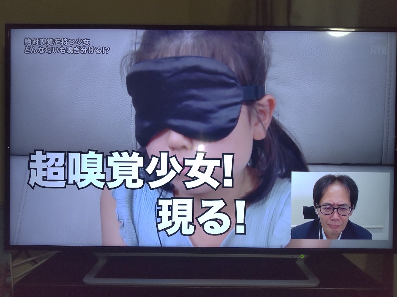 テレビ番組の画面で、目隠しした少女と「超嗅覚少女！現る！」という文章が表示されています