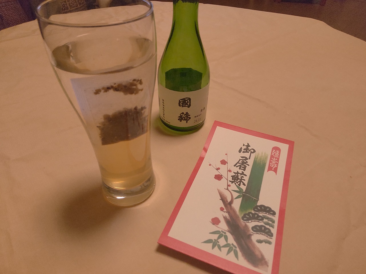 日本酒の入ったグラスと国稀とお屠蘇が写っています